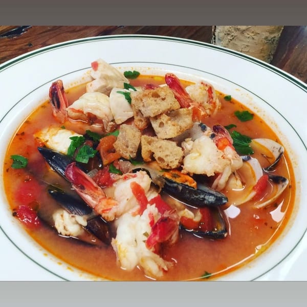 Seafood stew with shrimp, mussels, clams, and croutons in a rich tomato broth.